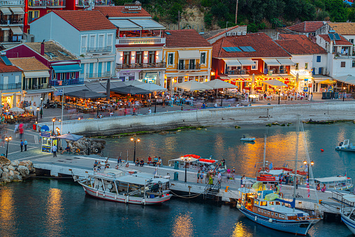 Amazing cityscape view of Parga city, Greece during the Summer. Beautiful architectural colorful buildings illuminated at night near the port of Parga Epirus, Greece