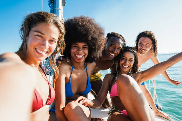 szczęśliwi wielorasowi przyjaciele robiący wycieczkę żaglówką - skup się na twarzy afrykańskiego mężczyzny - cruise ship cruise beach tropical climate zdjęcia i obrazy z banku zdjęć