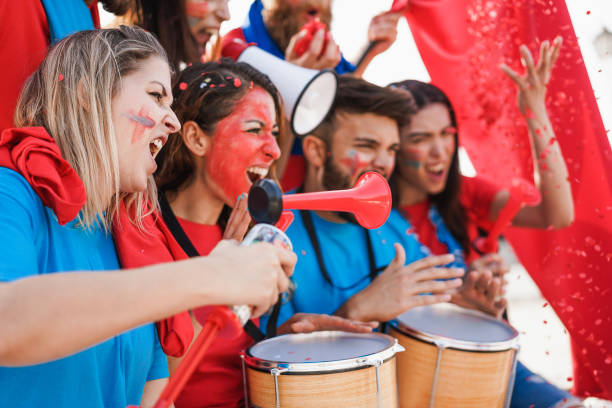 istock Crazy sport fans playing drums and screaming while supporting their team - Focus on left girl face 1408612573