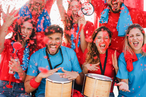istock Crazy football supporters playing drums and screaming while supporting their team - Main focus on right girls faces 1408612575