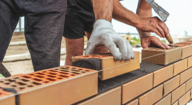 arbeiter- oder maurerhände, die ziegel aus der nähe legen. maurer arbeitet in der ziegelreihe. mauerwerk auf der baustelle - mason brick bricklayer installing stock-fotos und bilder