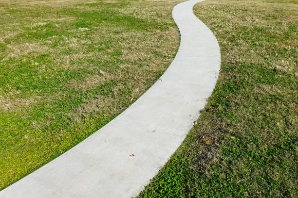 istock White road on the lawn square, symbol promenade park in spring 1408615601
