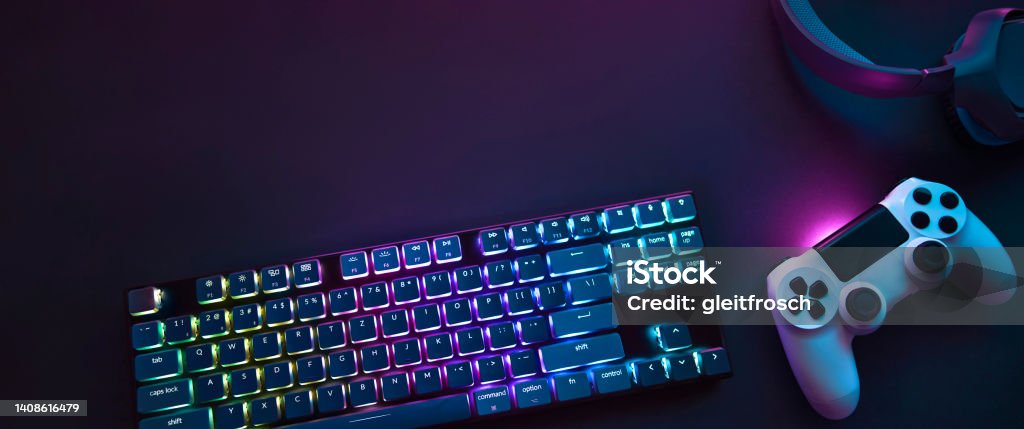 Top down view of colorful illuminated gaming accessories laying on table. Professional computer game playing, esports business and online world concept Top down view of colorful illuminated gaming accessories laying on table. Professional computer game playing, esports business and online world concept. High Angle View Stock Photo