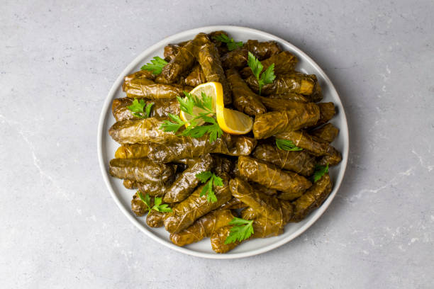 délicieux dolma (sarma) riz farci aux feuilles de vigne, sauce au yaourt blanc. dolma sarma libanais sur assiette. liban cuisine turque grecque moyen-orientale. (nom turc; yaprak sarma) - dolmades photos et images de collection