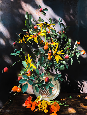 Romantic bouquets of flowers. Home decor and flowers arranging. In composition used rosehip, rudbeckia, nasturtium