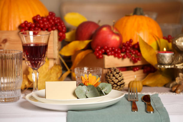 istock Beautiful autumn place setting with blank card and decor on table 1408622879
