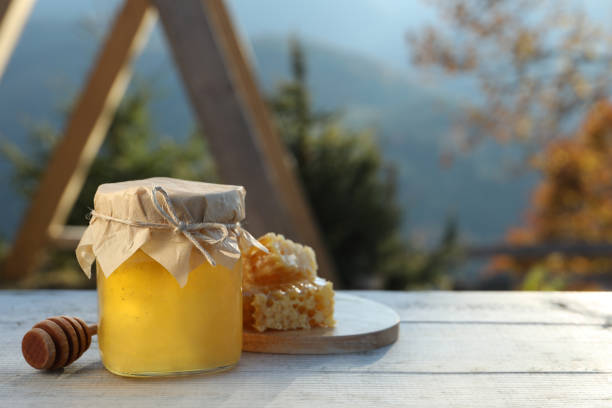 istock Fresh aromatic honey and combs on grey wooden table outdoors. Space for text 1408622966