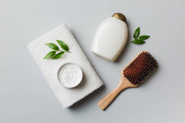 cosmetic for hair care, cream and towel on a colored background top view. flat lay stock photo
