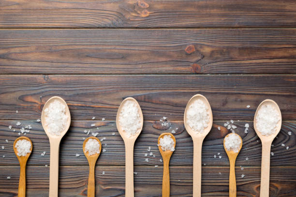 salt on many wooden spoon on wood background. Spoons with different salt salt on many wooden spoon on wood background. Spoons with different salt. rosemary dry spice herbal medicine stock pictures, royalty-free photos & images