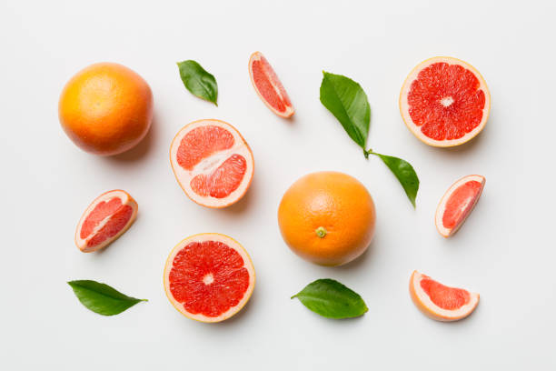 istock fresh Fruit grapefruit with Juicy grapefruit slices on colored background. Top view. Copy Space. creative summer concept. Half of citrus in minimal flat lay with copy space 1408626324