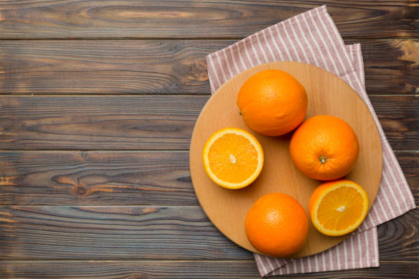 Fresh ripe oranges on cutting board on table. Top view Flat lay