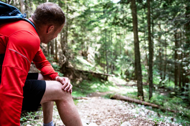 istock Hiker having trouble feeling knee pain during travel in forest 1408626857