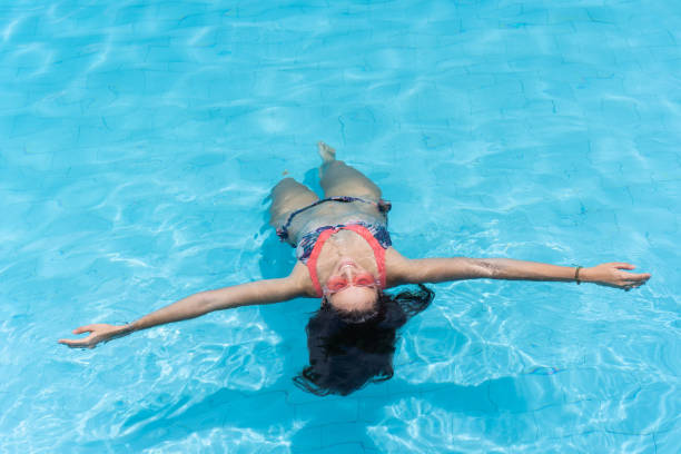 istock Woman floating on her back in pool 1408627975