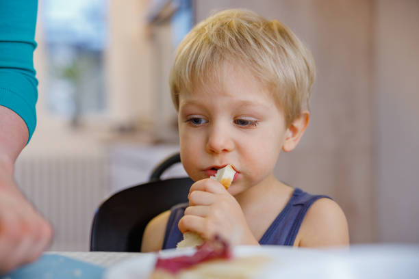 istock Blond toddler biting sliced bread, eating independently at home 1408627982