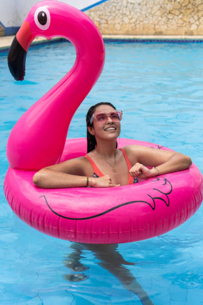 istock Woman standing on an inflatable ring floating in the pool 1408628052