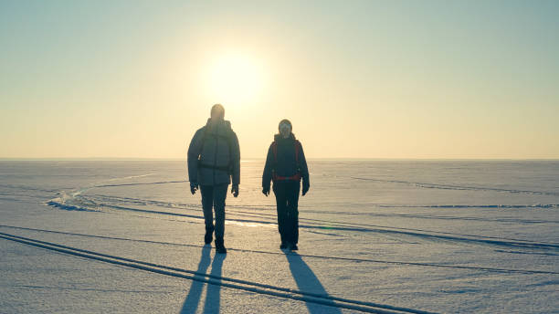 istock The two expeditors with backpacks walking through the snow field 1408629836