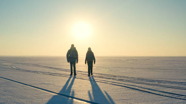 istock The two expeditors with backpacks walking through the snow field 1408629856