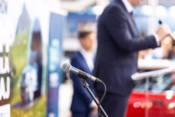 Public speaking or relations with copy space concept. Microphone in focus, blurred unrecognizable person in the background. Public speaking concept. Speaker giving a speech at business conference, presentation or media event. political rally stock pictures, royalty-free photos & images
