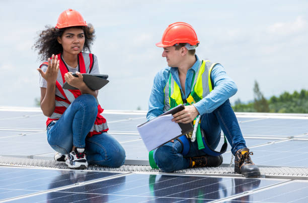 istock Engineer working setup Solar panel at the roof top. Engineer or worker work on solar panels or solar cells on the roof of business building 1408633971