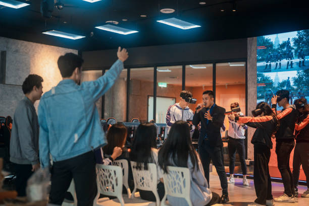asian game host emcee introducing 2 asian esports teams playing vr shooting videogame competing each other in grand final on stage - esport audience bildbanksfoton och bilder