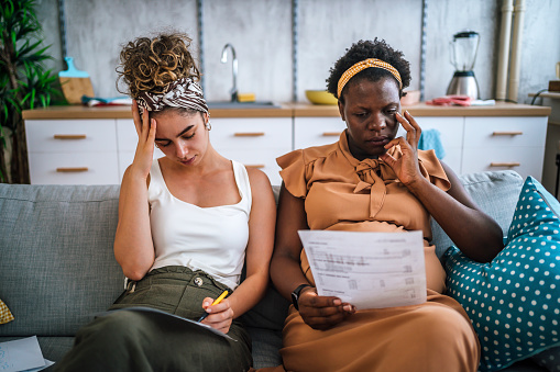 Young worried pregnant multi racial lesbian couple going through financials problems