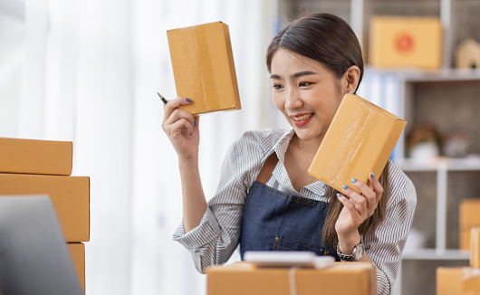 Portrait of young Asian woman working SME with a box at home the workplace.start-up small business owner, small business entrepreneur SME or freelance business online and delivery concept.