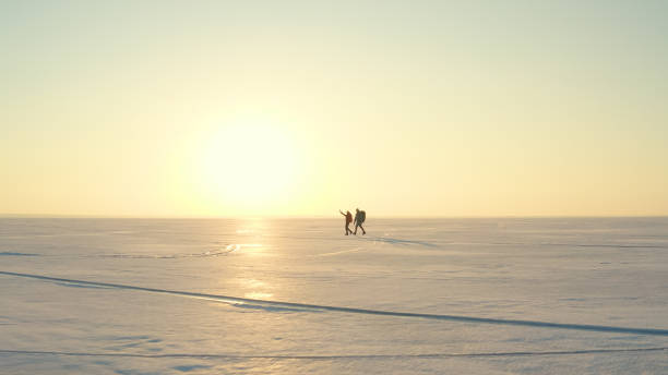 istock The two tourists going through the snow field against beautiful sky 1408639436