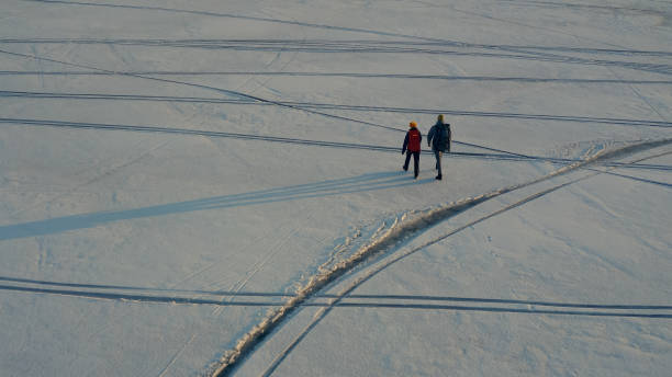 istock The two tourists going through the snow field 1408639440