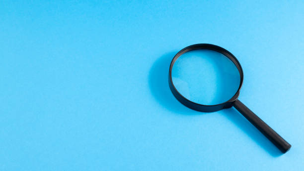 istock Searching for informational data on the Internet. Information search concept. Magnifying glass on a blue background. View from above. Copy space. Place for text. 1408639581