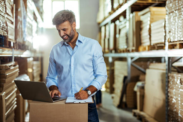 istock Warehouse logistic supervisor working on laptop at warehouse store 1408640921