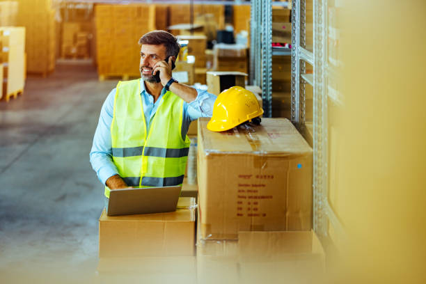istock Man with laptop and smartphone at warehouse 1408641181