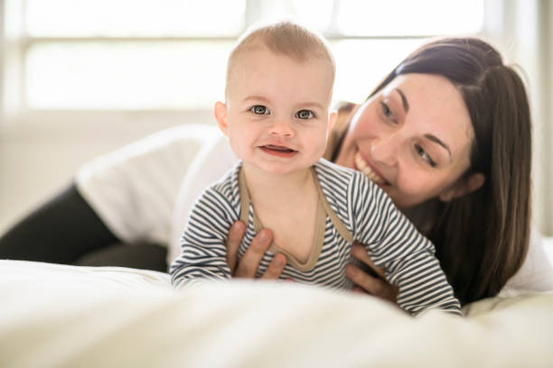 istock Mother and baby on white bed at home 1408645536