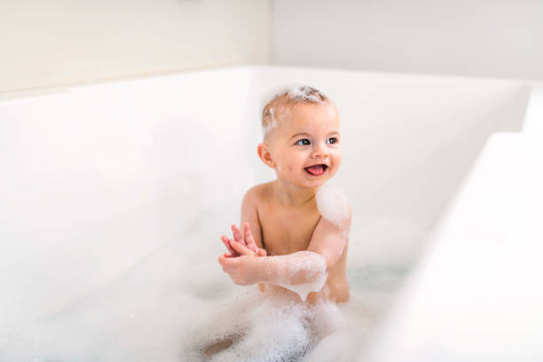 istock Baby boy bathes in a bath with foam and soap bubbles 1408645629