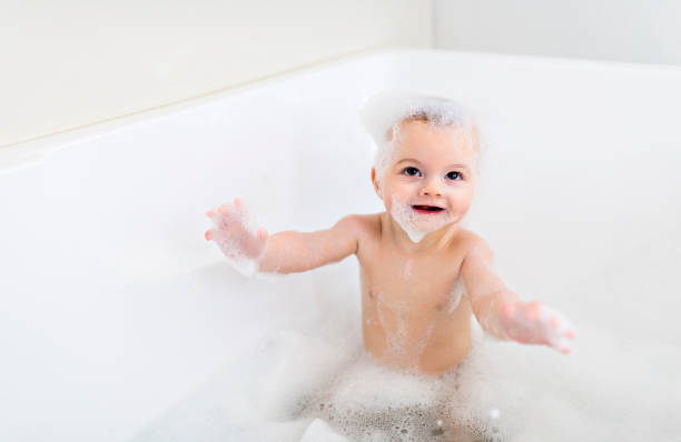 istock Baby boy bathes in a bath with foam and soap bubbles 1408645643