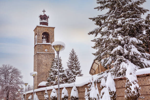 Street view with church bell tower covered with snow, Bansko, Bulgaria