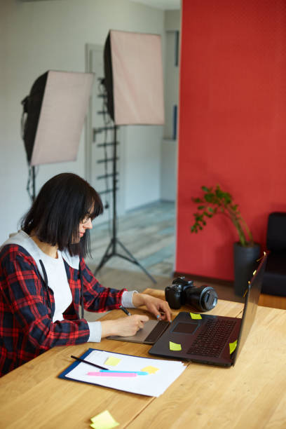istock Creative female photographer, using graphic drawing tablet and stylus pen 1408649672