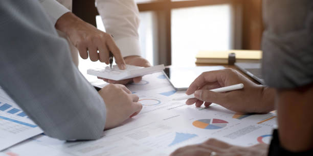 istock Business People Meeting using laptop computer,calculator,notebook,stock market chart paper for analysis Plans to improve quality next month. Conference Discussion Corporate Concept 1408652184