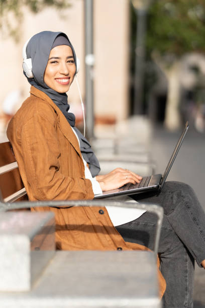 istock Woman turning to smile to camera while working with laptop 1408652261