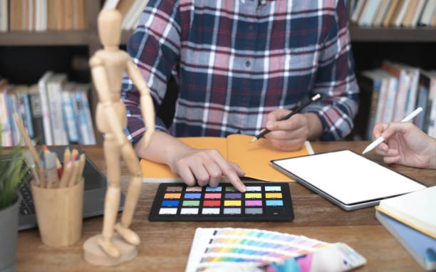 タブレット、オフィスのワークスペースに色用紙トーンに取り組んでいる 2 つのアーティスト - computer programmer graphic designer graphic design studio designer ストックフォトと画像