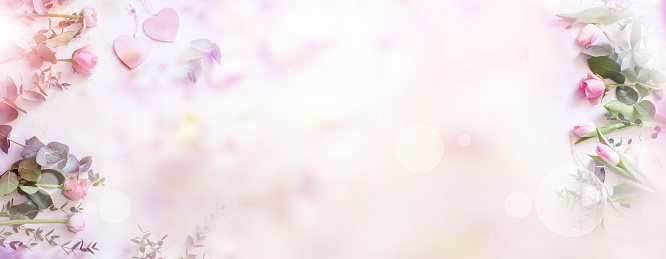 Wedding background. Floral dekoration on tender pink bokeh background. Horizontal top view for wedding cards and banner.