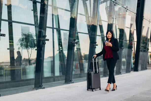 istock A female entrepreneur is dragging a suitcase with her and using a smart phone 1408661690