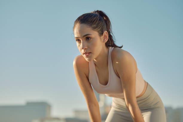 Young female athlete getting serious before a run outdoors in the city with copyspace. Young fit woman doing breathing exercises, preparing her body for a healthy cardio, endurance and speed workout joven atleta femenina tomando un descanso antes de una carrera al aire libre en la ciudad con copyspace. mujer joven en forma haciendo ejercicios de respiración, preparando su cuerpo para un entrenamiento saludable de cardio, resistencia y velocidad