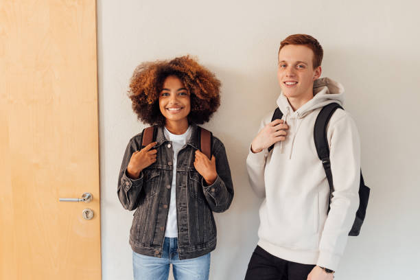 istock Two students standing together at wall and looking at camera 1408663833