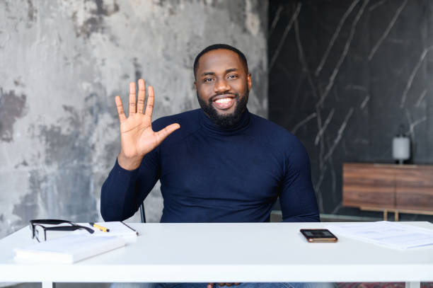 istock Smiling African-American man waving hello, video call 1408664465