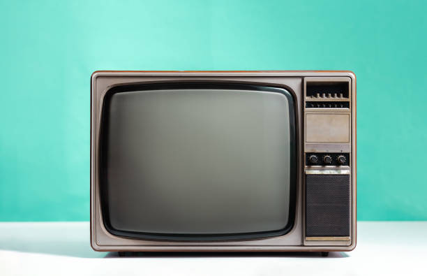 istock Retro old TV receiver on white table with gradient aquamarine wall background. Vintage television style 1408665949