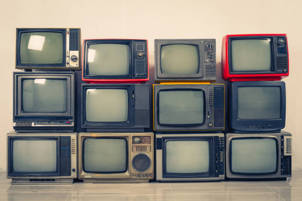 istock Retro old TVs pile on floor in the room. Television stack with vintage filter effect 1408666272