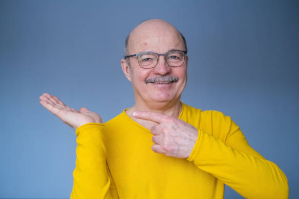 Senior man pointing with index finger to important information stock photo