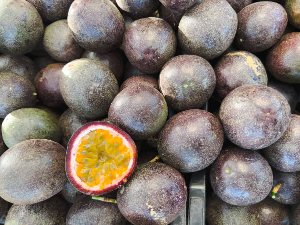 Horizontal high angle closeup photo of freshly harvested local Passionfruit for sale on a stall at the weekly Farmer’s Market in Byron Bay, north coast of NSW in Winter.