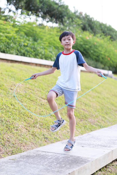 istock Little boy jumping rope on grass 1408675040