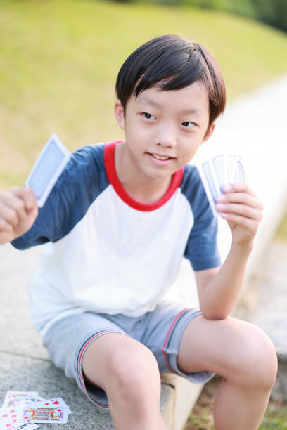 Boy playing cards Family playing cards child gambling chip gambling poker stock pictures, royalty-free photos & images